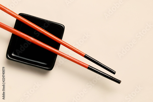 chopsticks over bowl with soy souse, copy space