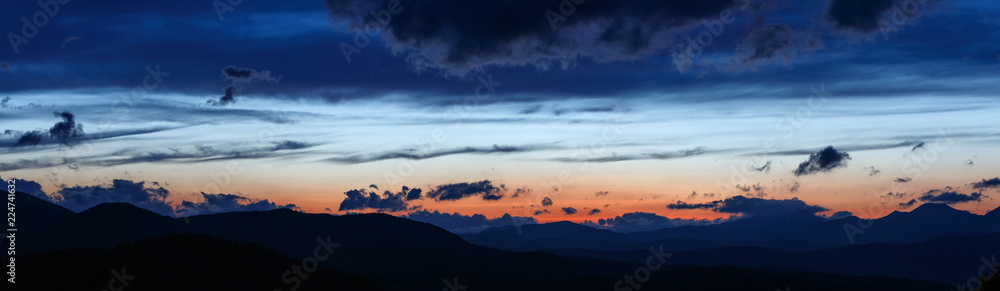 Sunset in the Carpathian Mountains. Silhouettes of the mountain range against the background of the evening sky.