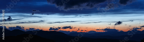 Sunset in the Carpathian Mountains. Silhouettes of the mountain range against the background of the evening sky. © serkucher