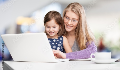 Happy mother with dauther using laptop at