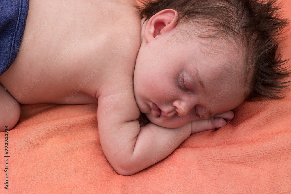 a newborn sleeps on a coverlet a newborn sleeps on a coverlet