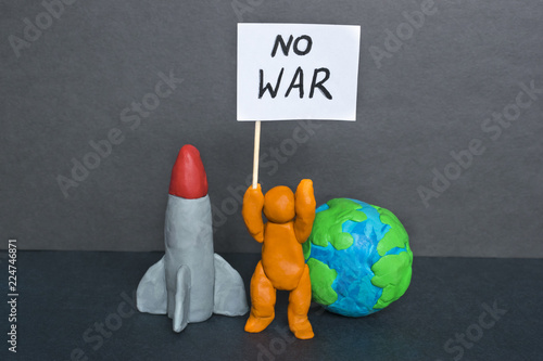 No war words, plasticine man and Earth on the dark background. photo