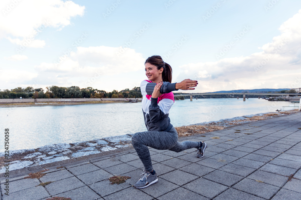 Athlete woman stretching arms in urban area