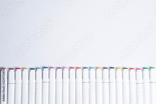 Top view of colorful markers on white background. Place for text