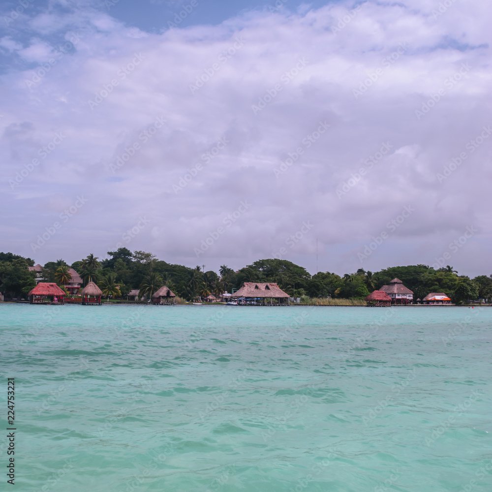 Tropical huts on Bacalar's lake and blue sky