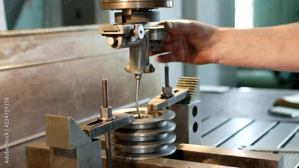 The man specialist checks the measuring tool for drilling a metal pulley, small business, sheave The man specialist checks the measuring tool for drilling a metal pulley, small business, sheave