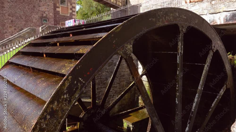 Large old iron water wheel slowly turning. Large old iron water wheel slowly turning.