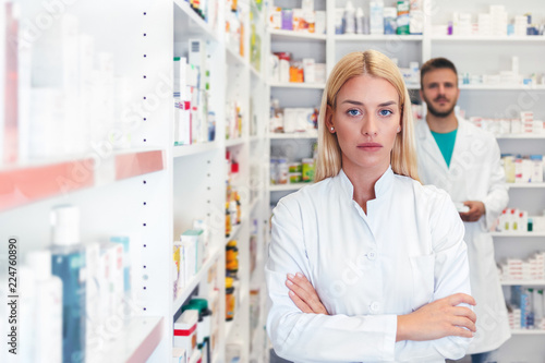 Serious pharmacists and chemists standing in pharmacy drugstore, looking at camera
