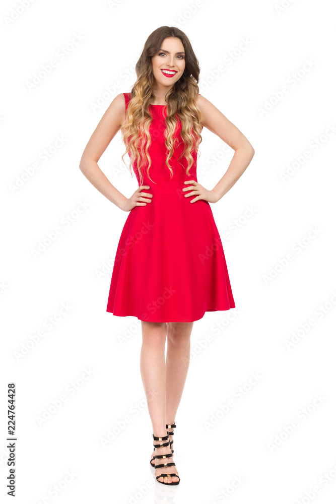 Smiling Beautiful Young Woman In Red Mini Dress Is Holding Hands On Hip Smiling Beautiful Young Woman In Red Mini Dress Is Holding Hands On Hip