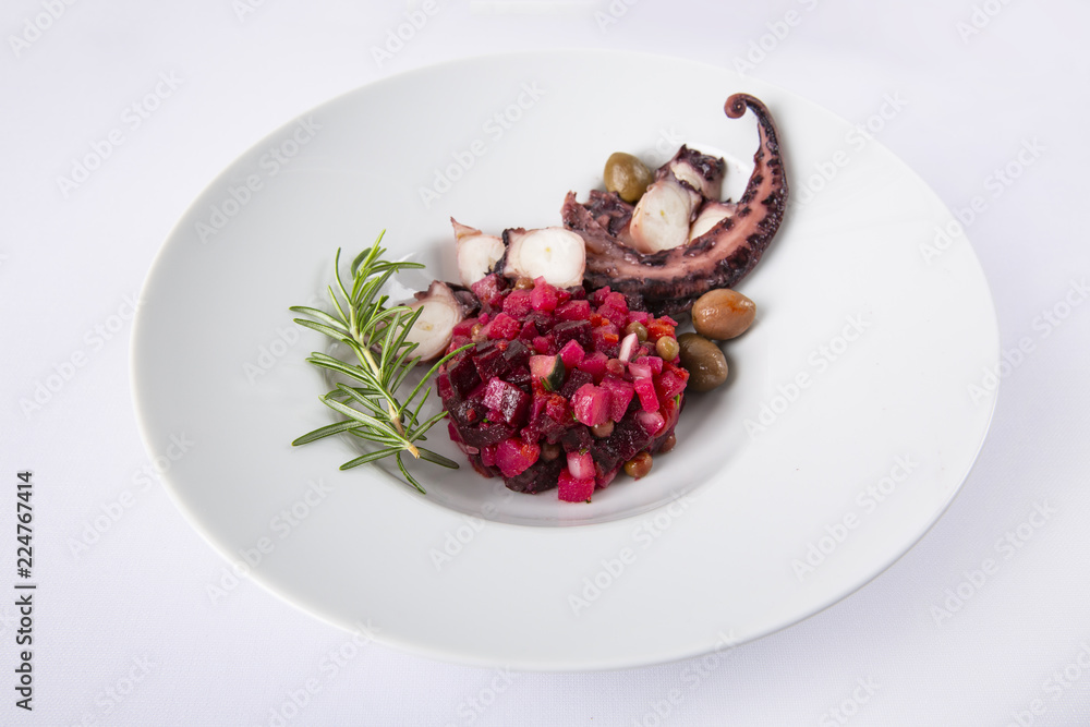 Salad from beet and octopus. Vinegret is a traditional Russian salad made from beets and vegetables. The background is white. Copy space. Horizontal shot. Salad from beet and octopus. Vinegret is a traditional Russian salad made from beets and vegetables. The background is white. Copy space. Horizontal shot.