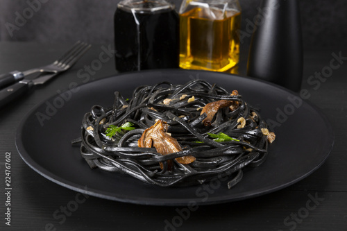Pasta with wheat germ and black squid ink. Mushroom sauce. Olive oil and spices. Copy space.