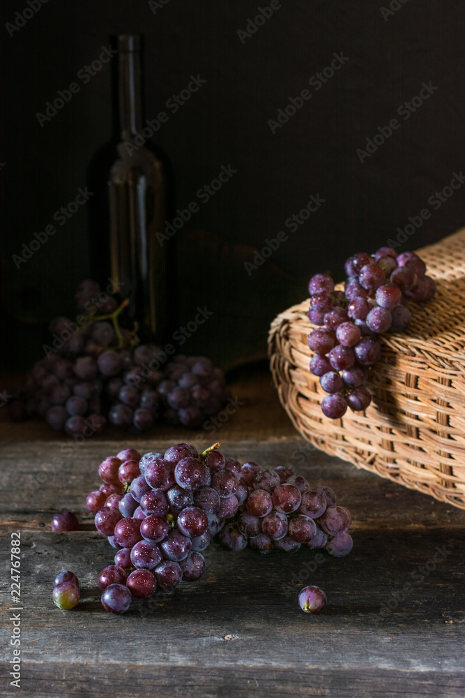 Bunches of fresh ripe red grapes on a wooden textural surface. Branch of pink grapes. Red wine grapes. dark grapes. Still life of food. Nature. Autumn harvest. Vegetarian nutrition. Winery.
