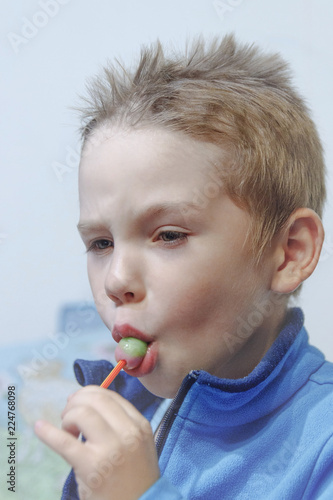 Obraz na płótnie the boy eats Lollipop intently w salonie