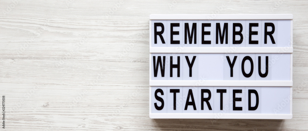 Lightbox with 'Remember why you started' words over white wooden background, overhead. Copy space. Lightbox with 'Remember why you started' words over white wooden background, overhead. Copy space.