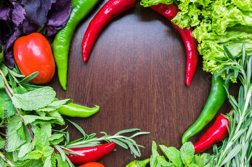 Different organic vegetables on a wooden background.
