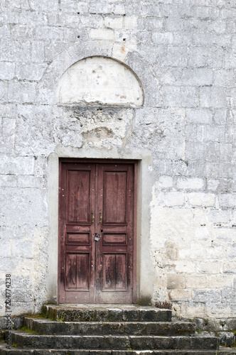 Ancient wooden door in stone castle wall. © Юрий Бартенев