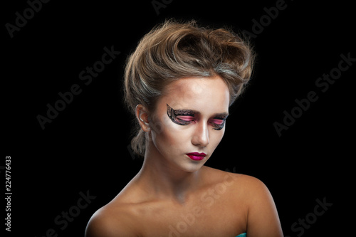 Halloween. Portrait of young beautiful girl with make-up. Isolated on black background.