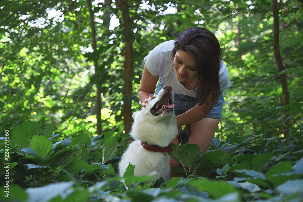 Young woman hugging and tapping her dog Young woman hugging and tapping her dog