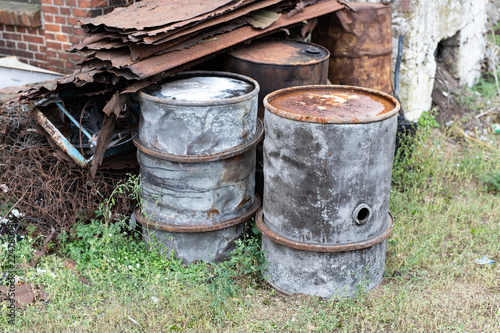 Old barrels for diesel. Metal containers for oil standing on the scrap yard.