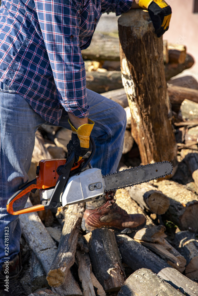 The worker works with a chainsaw. Chainsaw close-up. The worker works with a chainsaw. Chainsaw close-up.