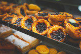 Traditional Portuguese egg tart pasty cakes, dessert Pasteis de nata with different portuguese pastry on the cafe store window, pastel de nata