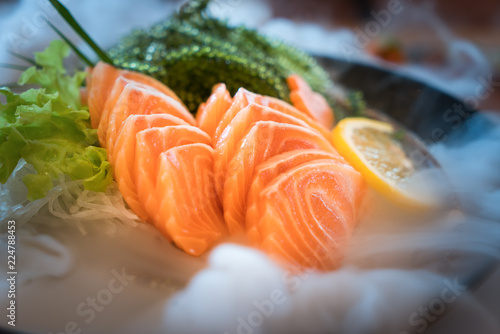 Raw salmon slice or salmon sashimi in Japanese style fresh serve on ice in bowl.
