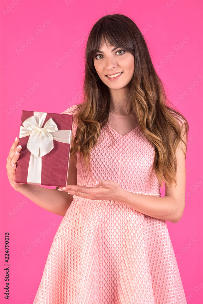 Young woman in a pink dress with gift box present Young woman in a pink dress with gift box present