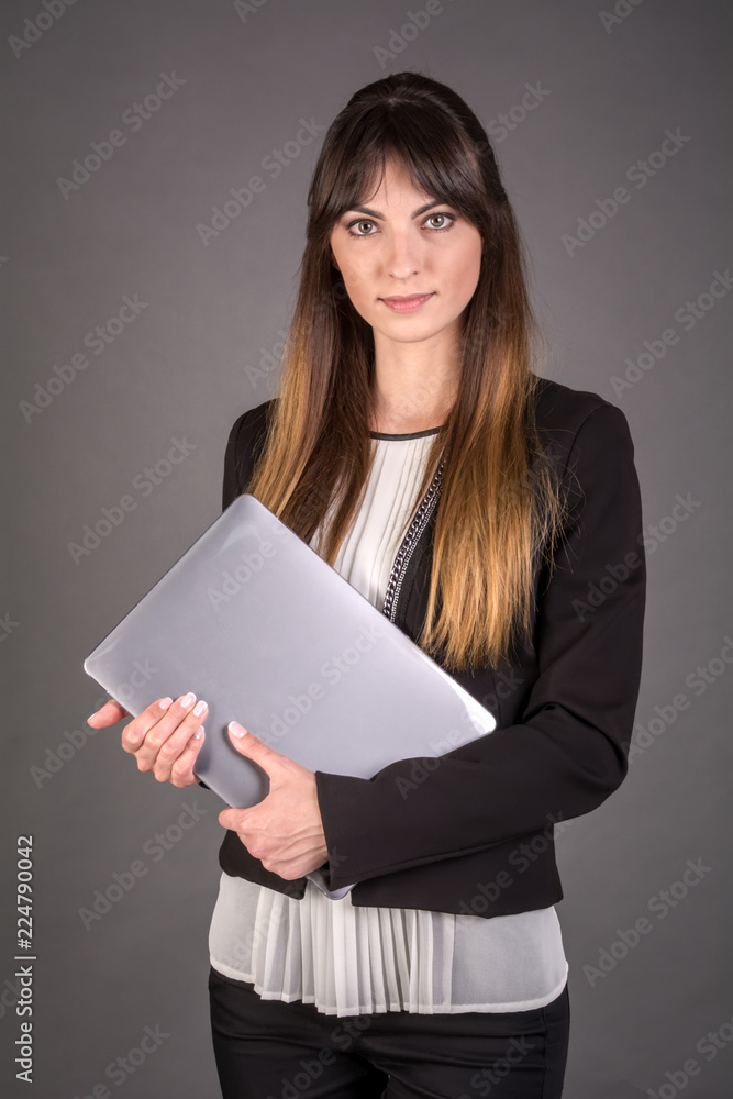 Business woman with a laptop on a gray background. Office worker. Business woman with a laptop on a gray background. Office worker.