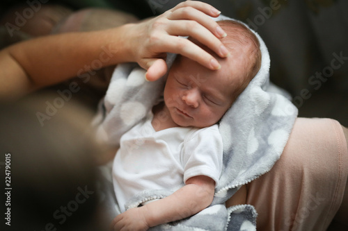 sweet newborn baby and gentle mom hands, lifestyle