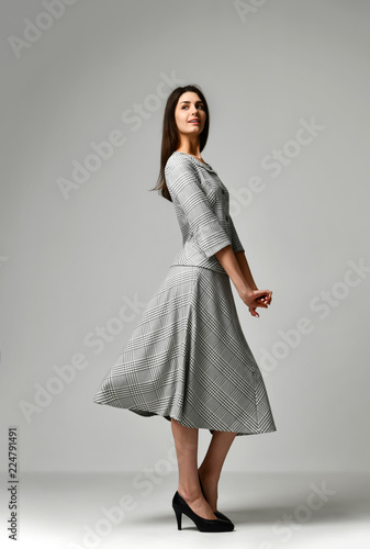 Beautiful woman posing in new grey casual office dress on gray background