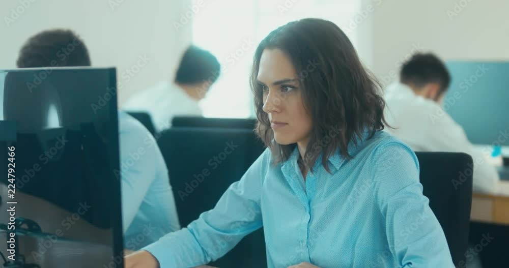 Attractive mid 30s Caucasian female working in the office, looking on a computer screen. 4K UHD 60 FPS SLOW MOTION Attractive mid 30s Caucasian female working in the office, looking on a computer screen. 4K UHD 60 FPS SLOW MOTION