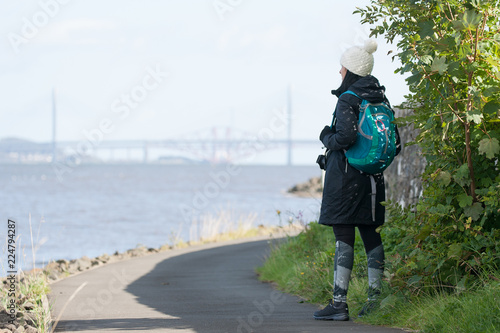 hiker looking on to forth bridges in scotland photo