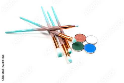 isolated colourful makeup eye brushes kit mint blue with skin powder top view on white