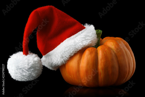 Single orange pumpkin with Christmas Santa hat photo