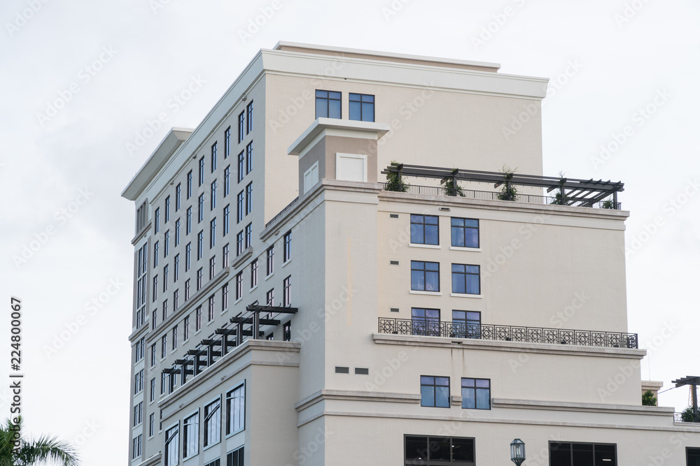 Day time exterior establishing shot of generic apartment, hotel, or condo building in tropical vacation destination location during summer time weather.