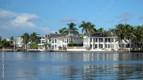 Typical luxury riverfront summer homes along quiet river in tropical southern location on beautiful summer day. Exterior generic establishing shot © Brandon Klein
