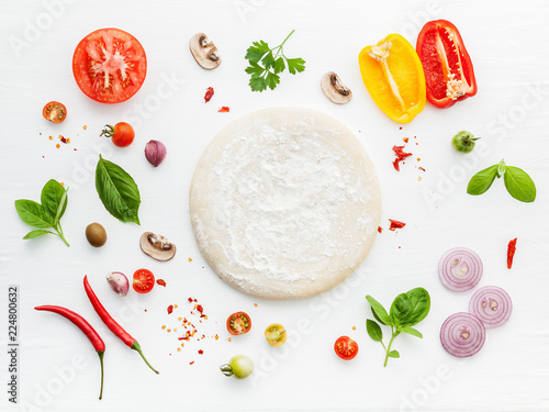 The ingredients for homemade pizza on white wooden background.