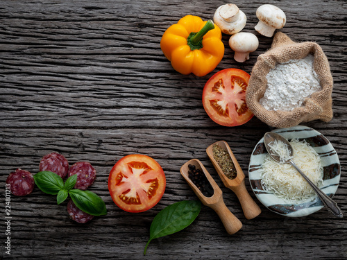 The ingredients for homemade pizza on shabby wooden background.