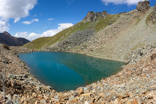 Hiking trail in Aosta valley, Cogne, Italy. Alpine lake of Garin. Photo taken at an altitude of 2900 meters.