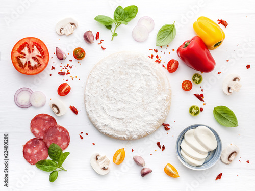 The ingredients for homemade pizza on white wooden background..
