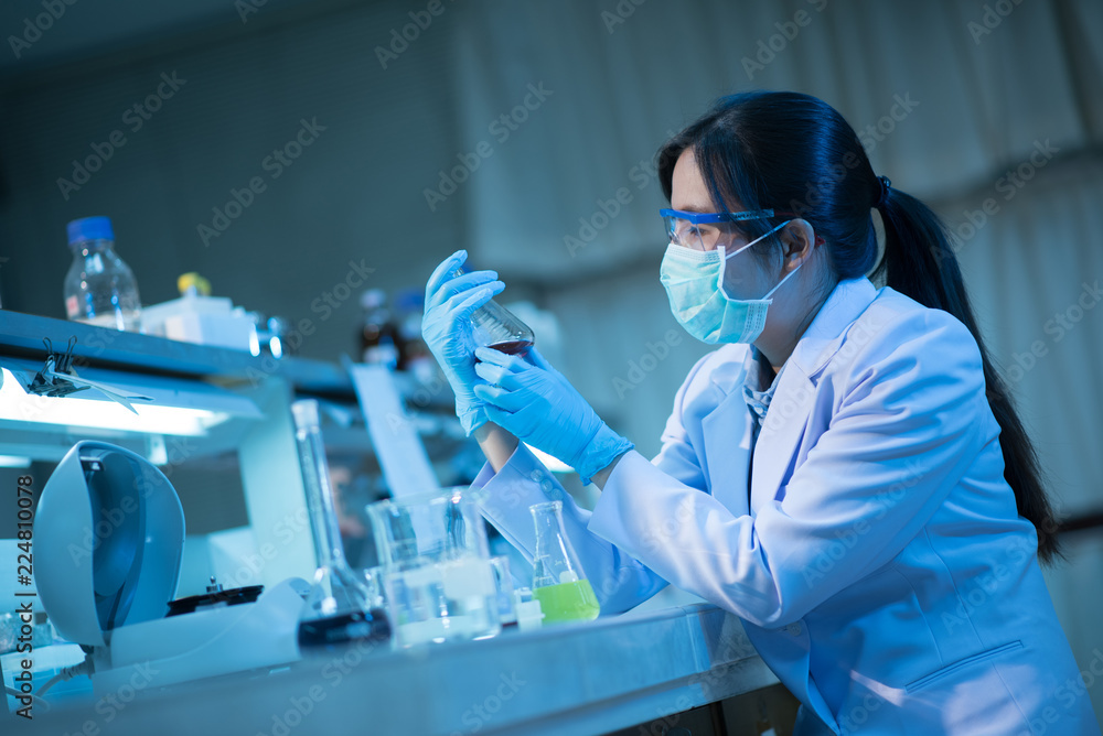 Young female scientist or researcher in medical lab with test tube centrifuge and flask Young female scientist or researcher in medical lab with test tube centrifuge and flask