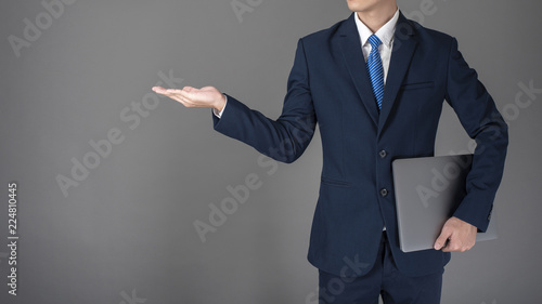 Business man is using laptop ,grey background in studio