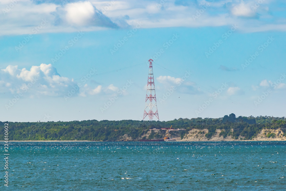 Electric high tension tower by the sea