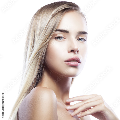 Close-up portrait of young beautiful girl model with nude make-up, clean skin, blond hair style touching body, on white background. Skincare facial treatment concept