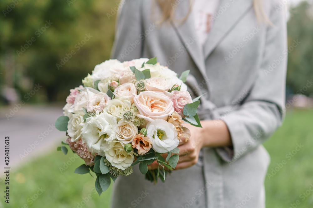 spring mood. Young girl holding a beautiful wedding bouquet. flower arrangement with white and Pastel color flowers. spring mood. Young girl holding a beautiful wedding bouquet. flower arrangement with white and Pastel color flowers.