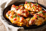 Chicken breast baked with monterey cheese and cheddar, bacon, tomatoes and barbecue sauce close-up. horizontal
