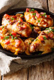 Delicious Monterey chicken breast baked with cheese, bacon, tomatoes and barbecue sauce close-up. vertical