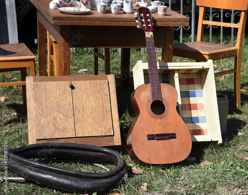 Flohmarktstand mit allerlei Trödel, Gitarre, Möbeln und Geschirr photo