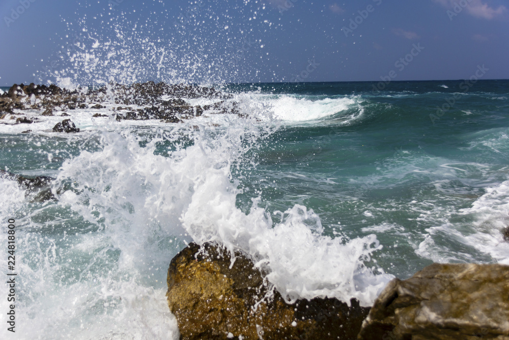 sea waves with foam breaking on the stones of the coastline, splashes of water flying around sea waves with foam breaking on the stones of the coastline, splashes of water flying around