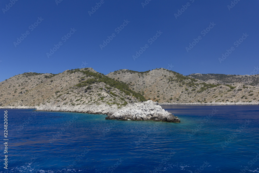 Fototapeta premium background image of rocky seashore on different Islands of Greece, Rhodes, KOs, Santorini, Halkidiki, Crete, Simi, Corfu